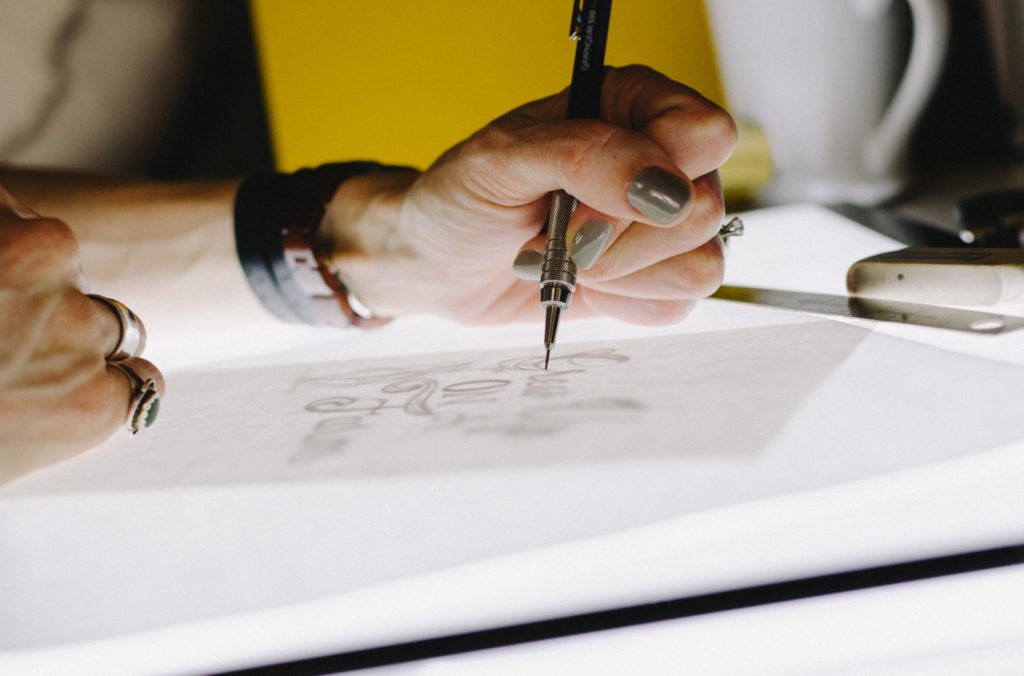 photo ov a womans hand drawing with a mechanical pencil by kelly-sikkema-o2TRWThve_I-unsplash illustrating Drawing Ideas for Artists website.